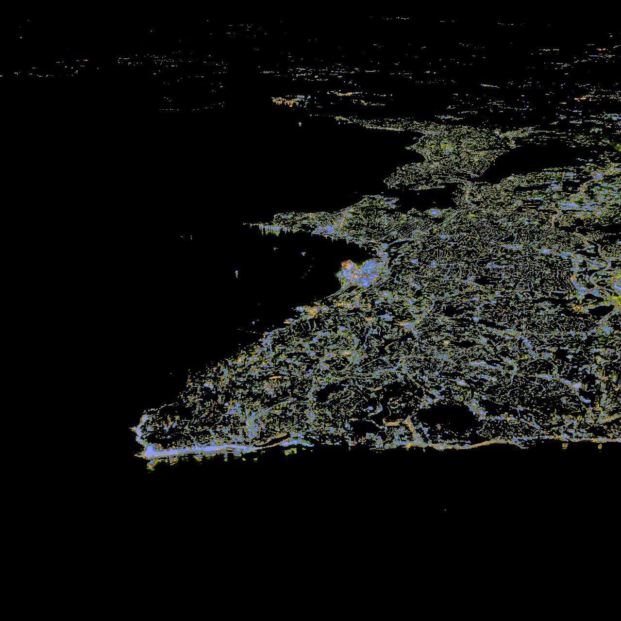 Slightly oversaturated picture of a city at night from the window of an airplane.